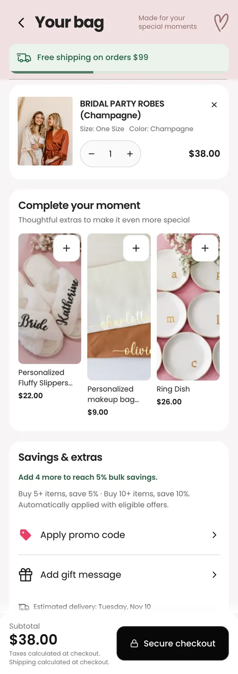 The new cart drawer on a phone: "Your bag", a green free-shipping progress bar, the robe with size, colour, a quantity stepper and price, a "Complete your moment" row of slippers, a makeup bag and a ring dish with add buttons, a "Savings & extras" card with bulk savings, promo code and gift message, and a black Secure checkout button.